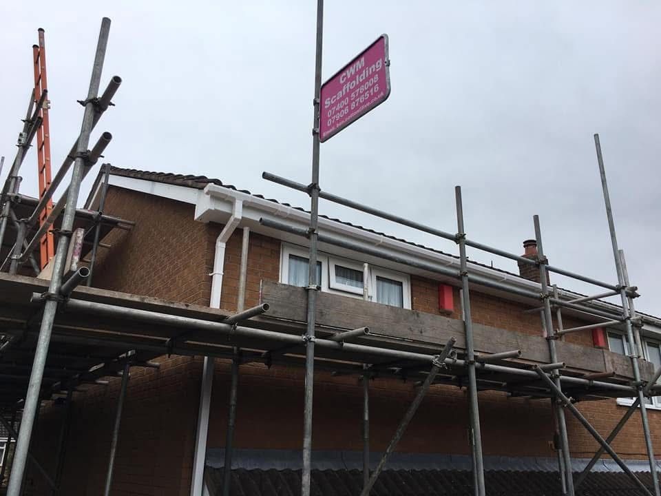 White uPVC guttering and fascia fitted to a brick house from scaffolding in Stoke-on-Trent