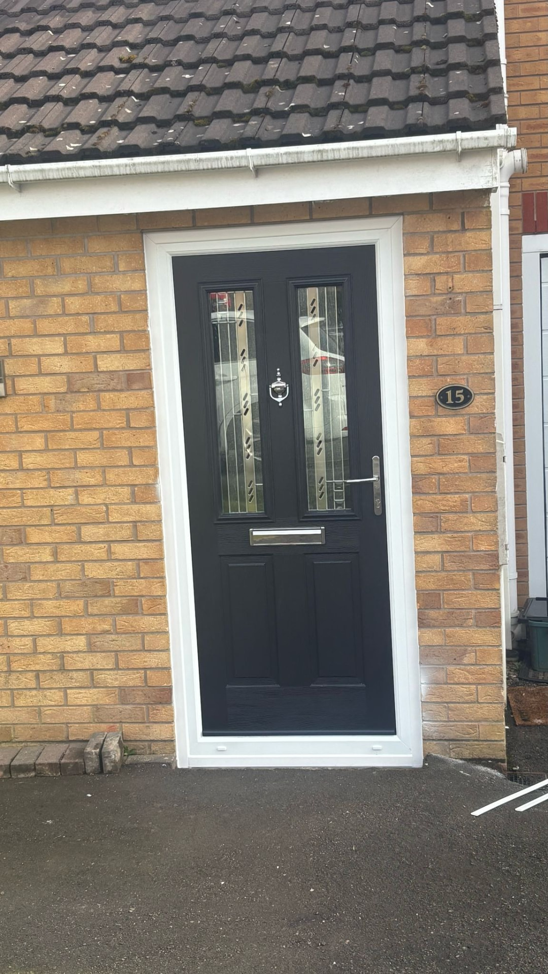 Black composite door with silver hardware and vertical glass panels fitted in Newcastle-under-Lyme
