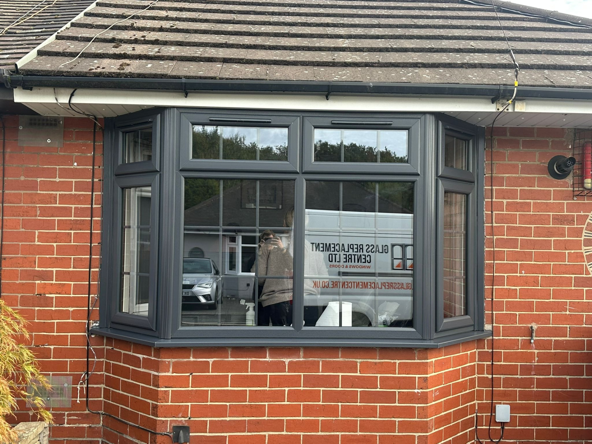 Anthracite grey uPVC bay window fitted to a red brick bungalow in Staffordshire