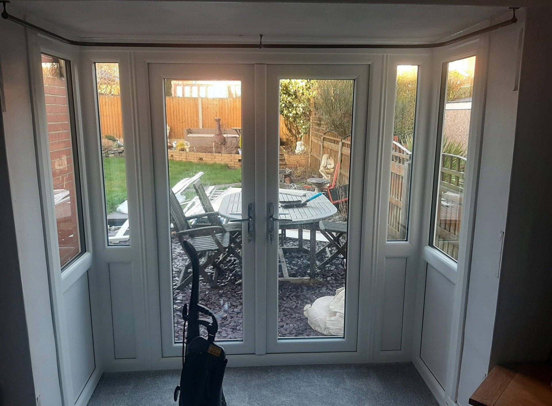 White uPVC French doors with side panels fitted into a bay opening, viewed from inside