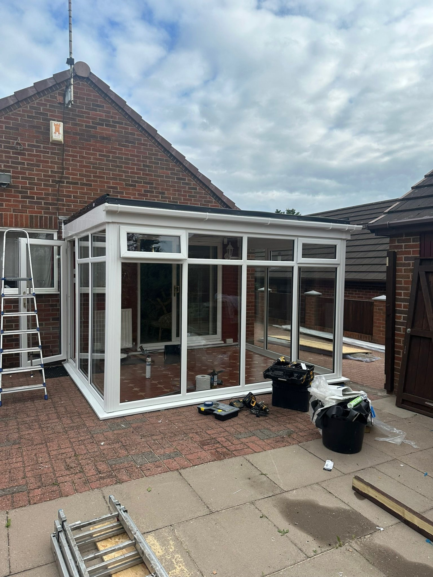 White uPVC conservatory and lean-to structure under construction in Staffordshire