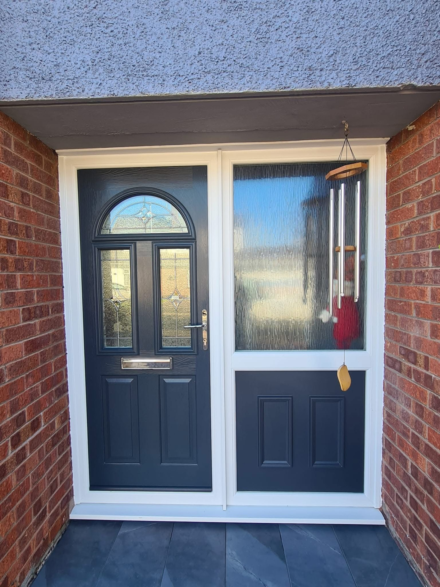Dark grey composite door with arched window and large frosted side panel