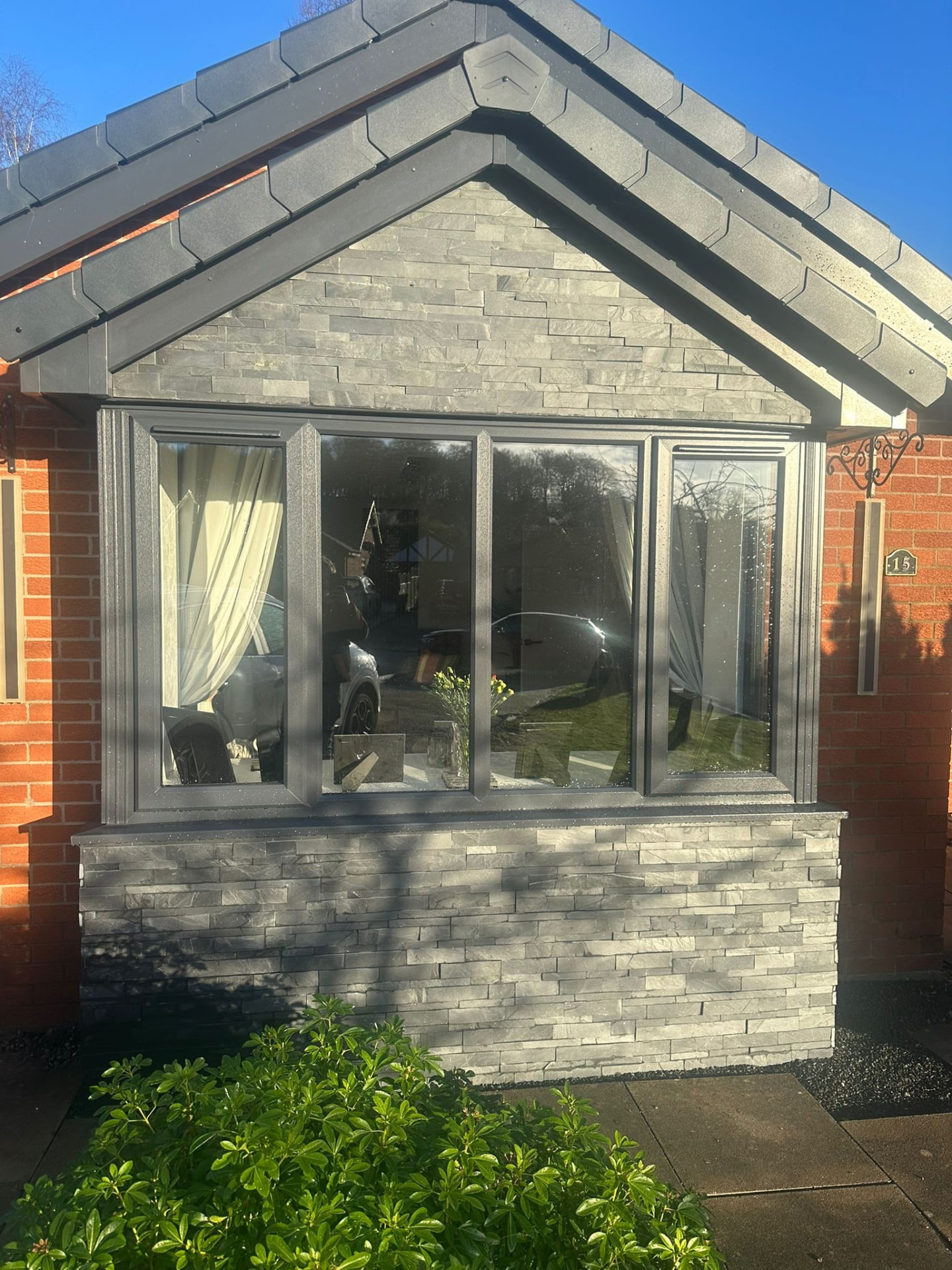 Modern grey window set into a slate-clad porch gable in Stoke-on-Trent