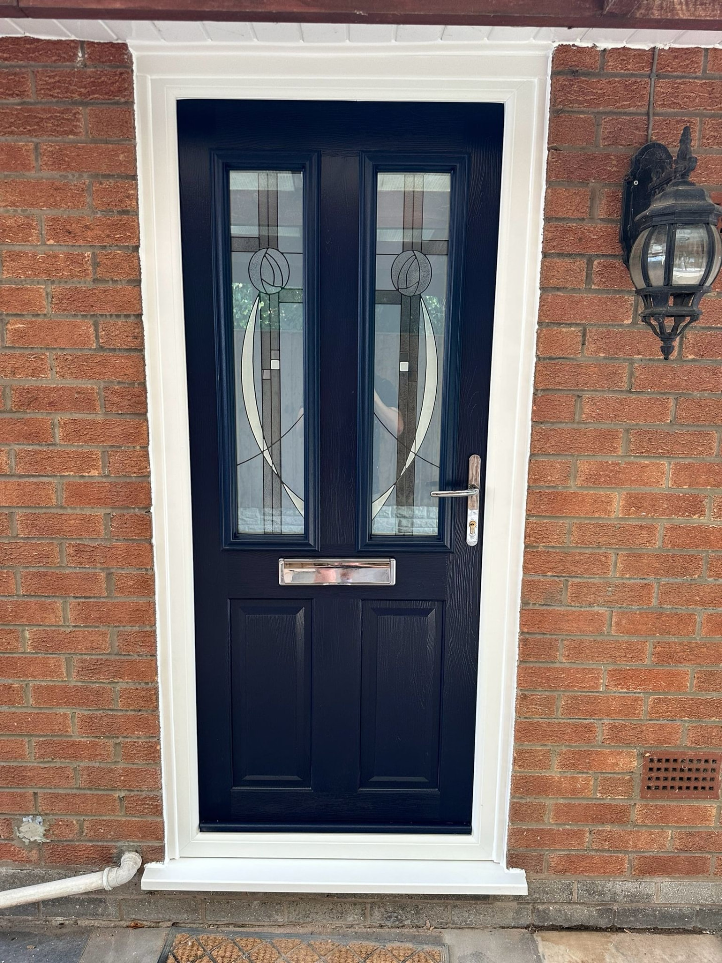 Navy blue composite door with rose-patterned decorative glass fitted by our Stoke-on-Trent installers