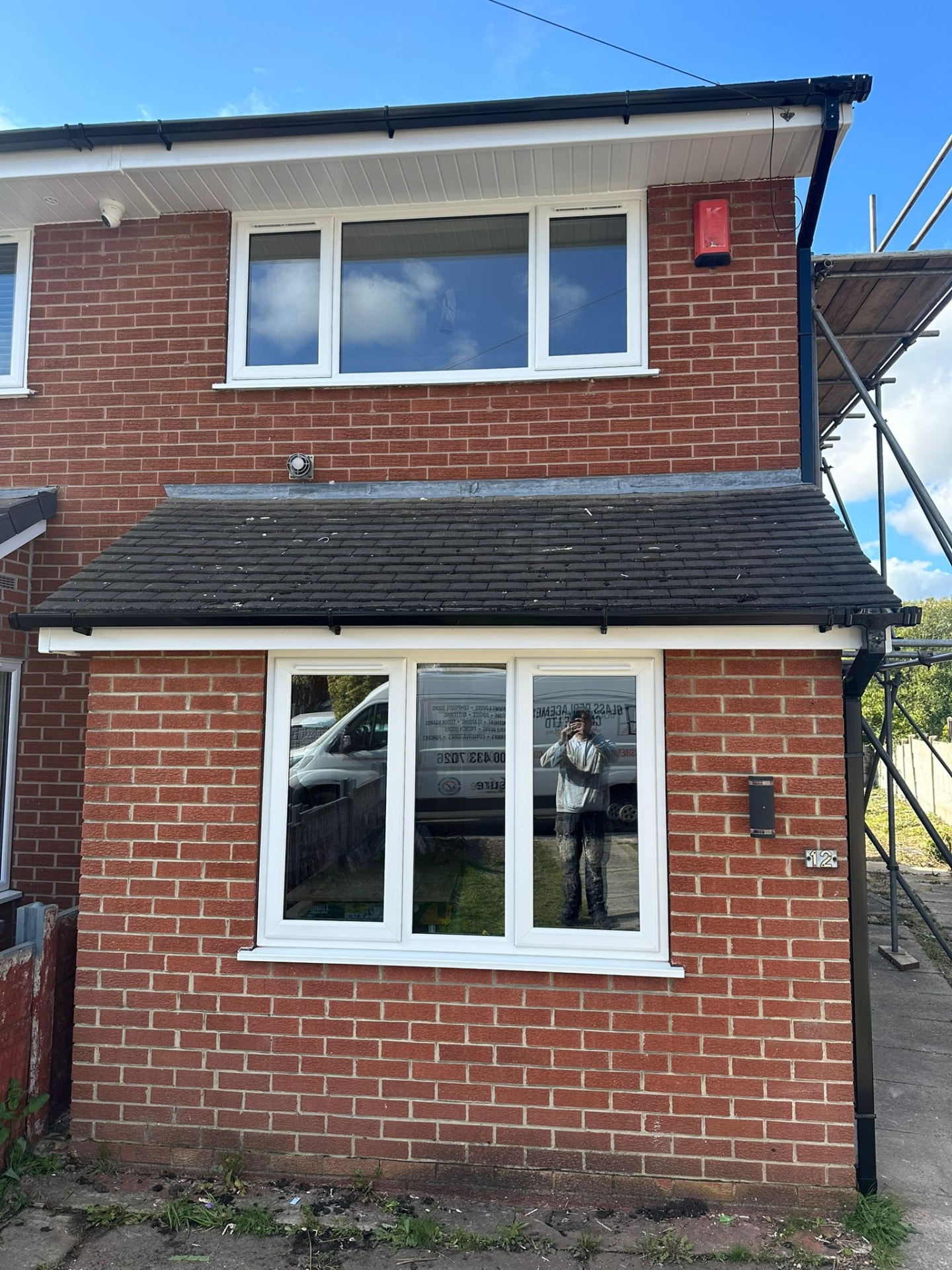 Red brick house with new white uPVC replacement windows across both floors